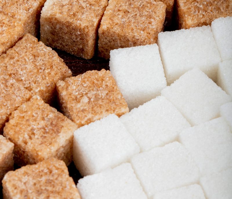 background of brown and white sugar cubes side view